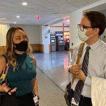Two fellows talking in the halls of Duke